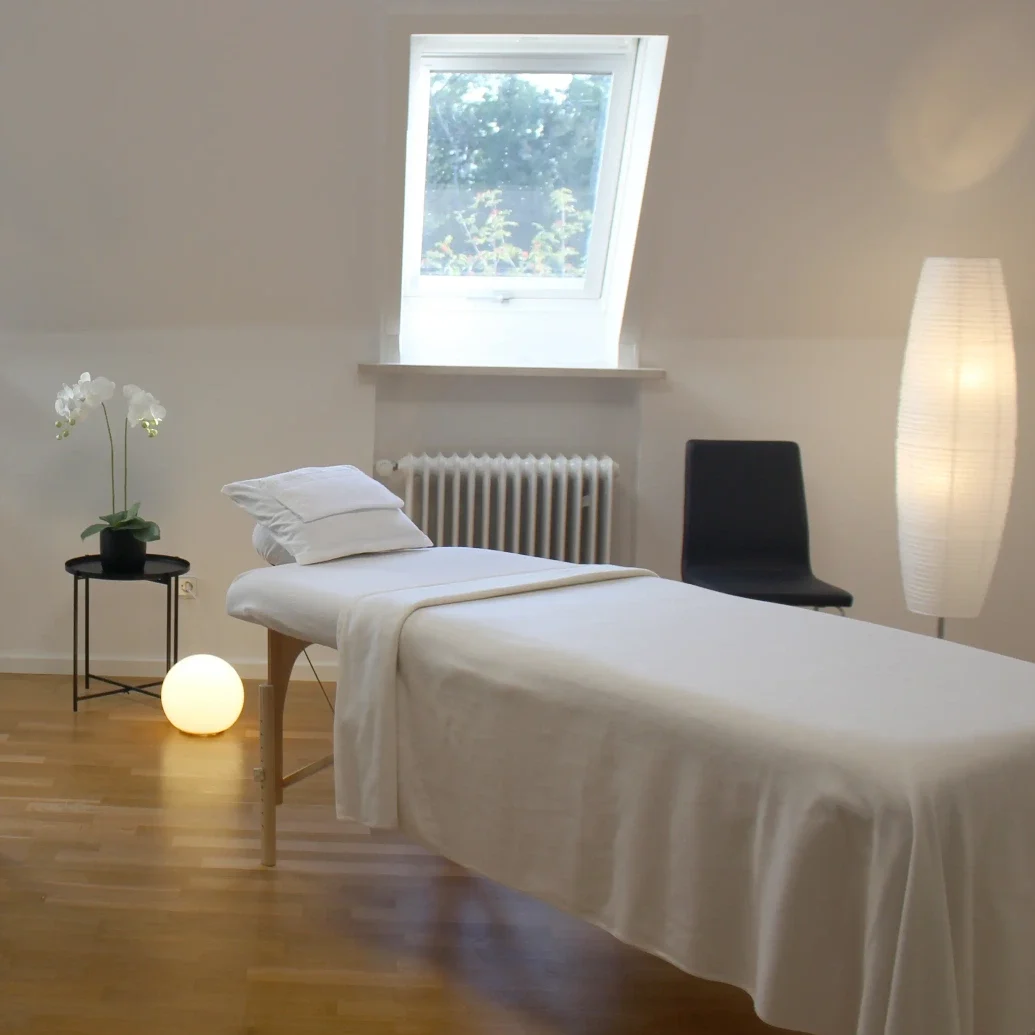 Moderner und heller Behandlungsraum mit Reik-Liege Ein heller, geschmackvoll eingerichteter Behandlungsraum mit einer Reiki-Liege.